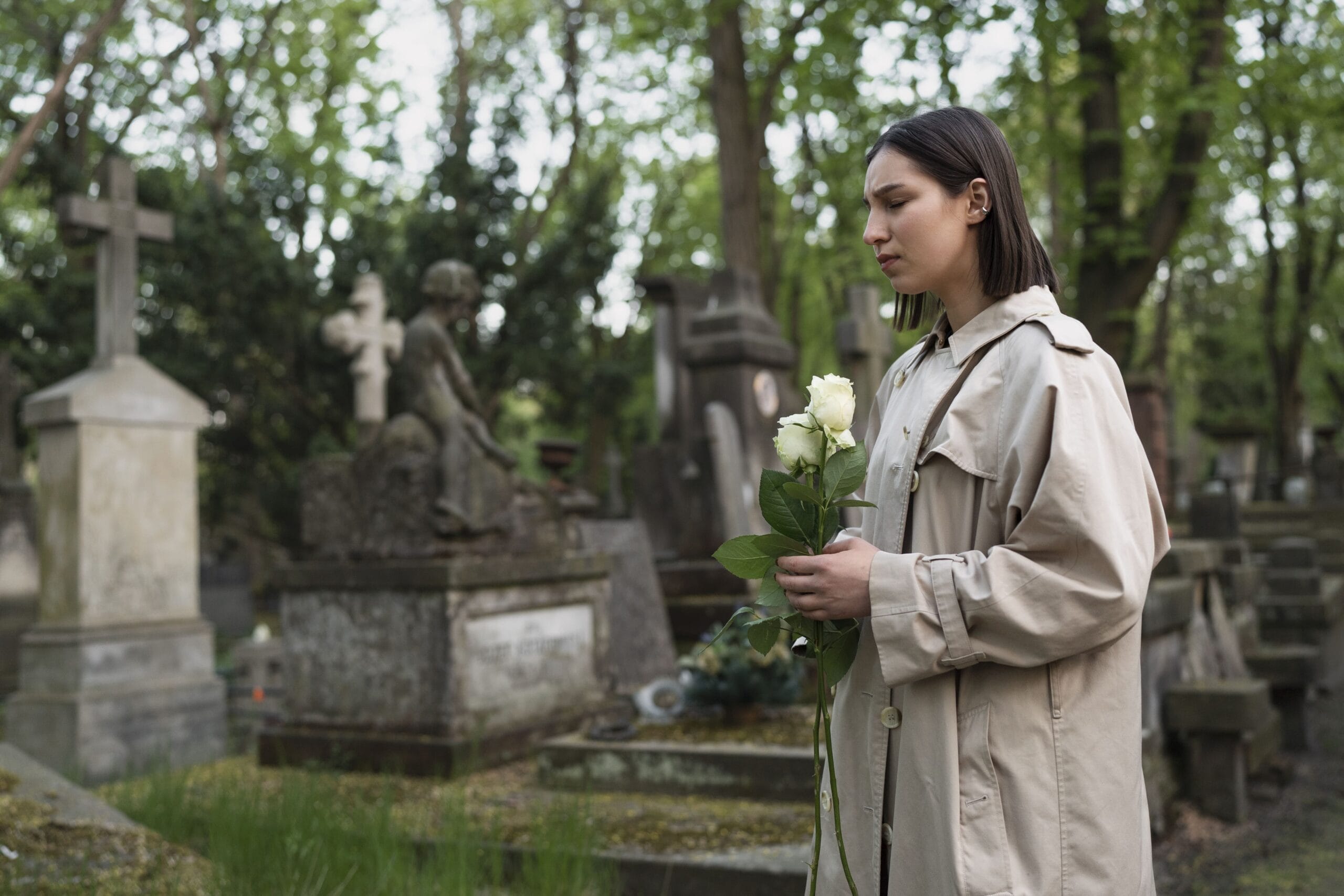 Chica visitando una tumba en un cementerio